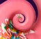 Twisted donut with strawberry icing and sprinkles on purple background, spiral effect