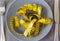 Twisted measuring tape on a brown plate on a gray background, top view, knife, fork, dishes, diet, concept, closeup