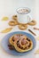 Twisted yeast buns with apples, raisins and cinnamon on a gray plate on a light concrete background. Harvest apples