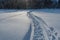 Twisting traces of a snowmobile crossing snow covered field