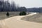 Twisting winding meandering gravel road in weald with signs near forest wood