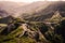 Twisty road in the mountains on a remote island. Garajonay national park. Mountain landscape with dense green forest and ocean.