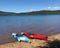 Two 2 red and blue kayak boats on lakeside beach