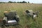 TWO ABANDONED EASY CHAIRS IN LONG GRASS