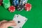 Two Aces and poker chips stack on green table