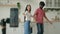 Two active bloggers record funny video clip in kitchen multiracial arabian woman indian man couple dancers dancing to
