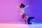 Two active young girls dancing hip-hop on gradient pink purple neon studio background