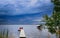 Two adirondack chairs on a pier overlooking a lake