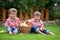 Two adorable boys, sitting on the grass, eating apples