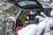 Two adorable brothers sitting in car at snowly winter forest. Concept holiday vacation