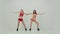 Two adorable cheerleaders in red and yellow shiny uniforms dance a gleeful dance and move their hips. Cheerleaders dance