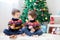 Two adorable children, boy brothers, eating cookies and drinking