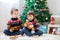 Two adorable children, boy brothers, eating cookies and drinking