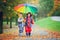 Two adorable children, boy brothers, playing in park with umbrella