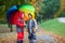 Two adorable children, boy brothers, playing in park with umbrella