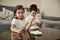 Two adorable children holding eggs and paintbrushes ready for coloring Easter eggs