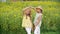 Two adorable girls in hats posing together on sunflower field