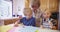 Two adorable little children drawing with grandmother