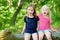 Two adorable little sisters hiking in a forest