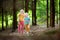 Two adorable little sisters hiking in a forest on summer