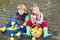 Two adorable little twin kids eating apples in home\'s garden, ou