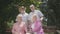 Two adorable mature couples talking and smiling at the bench in the summer park. Double date of senior couples. Friendly