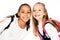 two adorable multicultural schoolgirls smiling while looking at camera isolated on white.