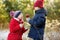 Two adorable sisters eating red apples covered with sugar icing on beautiful sunny Christmas day. Children enjoying sweets, candie