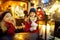 Two adorable sisters having rooster-shaped lollipops on traditional Christmas fair in Riga, Latvia. Children enjoying sweets,