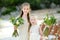 Two adorable young bridesmaids holding beautiful flower bouquets after wedding cemerony outdoors