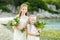 Two adorable young bridesmaids holding beautiful flower bouquets after wedding cemerony outdoors