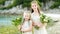 Two adorable young bridesmaids holding beautiful flower bouquets after wedding cemerony outdoors