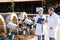 Two adult experts are standing in uniform and checking the quality of milk