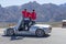 Two adult men stand inside a Spyder car while overlooking the mountain range at Red Rock Canyon Nature Conservancy