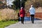 Two adult women walking with Hiking or trekking telescopic walking sticks on a Sunny day on the road in the city Park on
