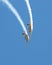 Two aerobatic aircraft perform a deep dive in a blue sky