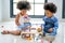 Two African brother and sister play some toys together in the room with day light with main focus on little girl