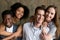 Two african and caucasian couples embracing looking at camera, p