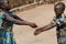 Two African Children Cleaning Hands Outdoors with Fresh Water