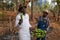 Two African farmers in plantain banana plantation, farmer holds bunch of bananas in hand