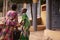 Two African Girls Carrying A Heavy Water Bucket Home From The Pumping Station