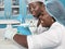 Two African scientists, technical assistants or graduates in lab coats and gloves perform PCR testing of patient samples in test