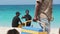 Two African teenagers eat fruit on Nakupenda beach in Sunny day, Zanzibar