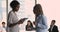 Two African women colleagues walk along boardroom discuss project