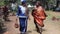 Two African women walk while having a conversation, they are traditionally dressed
