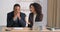 Two afro american men sitting at table in office businesswoman telling secret to businessman whispering into male ear