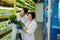 Two agriculturists wearing blue gloves looking at greens