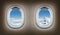 Two airplane windows. Jet interior.