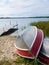 Two aluminum boats pulled up on shore with a dock in the background