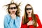 Two amazed teen girls in cinema wearing 3D glasses experiencing 5D cinema effect - wind blowing into faces